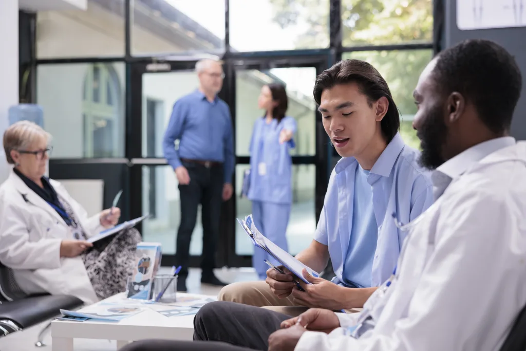 Doctors speaking with a diverse group of patients in a clinic